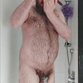 Hairy chastity bear showers and fingers his hole