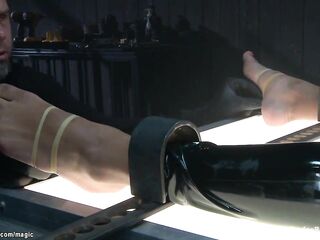 Chained and lied on her back in latex costume black serf Daisy Ducati gets feet tormented then spanked and whipped and anal fingered by slaver The Pope