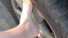 Rubbing truck tire with bare feet