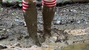 Striped knee-length socks in mud, dirty feet stuck in mud, girl walking through mud in socks