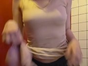 Charming girl takes off her bra from under her T-shirt