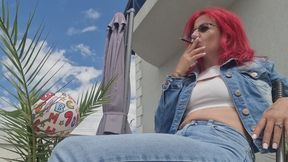 SMOKING JEANS GODDESS DESTROYS A SOCCER BALL WITH CIGARETTES.