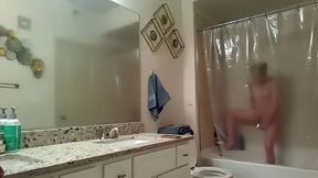 Blonde masturbates and cums hard with a showerhead standing, takes a selfie of her pink pussy after