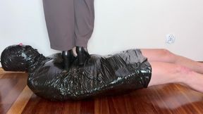 First boots trampling wrapped slave