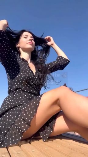 Blonde woman in polka dot dress sitting on roof