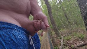 Perverted guy pisses in a condom in the deep woods