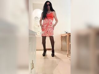 Gorgeous and lascivious Spanish trans girl with long legs cums in an orange dress, skirt and top, black heels, and lingerie