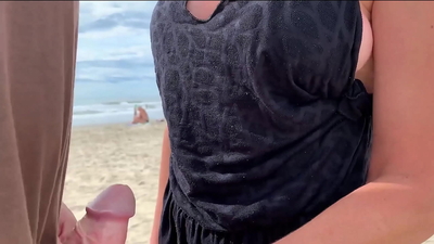 Milf holds my penis tightly in her hand until I cum right on the beach