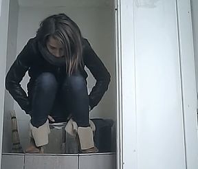 White young chick in leather jacket and jeans filmed in the toilet