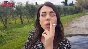 Outdoors smoking cigar from sexy brunette