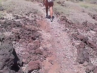 Couple is hiking naked near the coast
