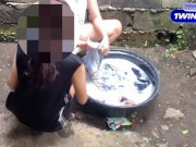 two pinay playing at each other while washing clothes outside