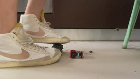 Old ruined Toy cars crushed under Nike blazer and fila disruptor sweaty sneakers