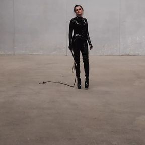 The Goddess Obsidian wields her bullwhips ominously in her latex catsuit.