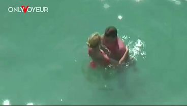 Beach Voyeur. Secretly fucks his girlfriend in the water on a public beach