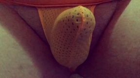 Playing with my bulge in a tiny orange mesh thong