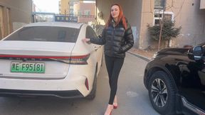 A girl in high-heeled shoes plays with her shoes and feet in the car