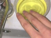 Girl Pissing into a container and plays urine with fingers. 3rd day of ovulation test
