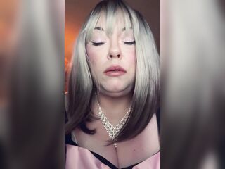 big beautiful woman Golden-haired Tina Snua Smokes A Slender Cigarette In A Holder In Satin Gloves With Rings