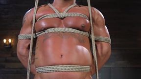 Muscle hunk gagging on cock while bound