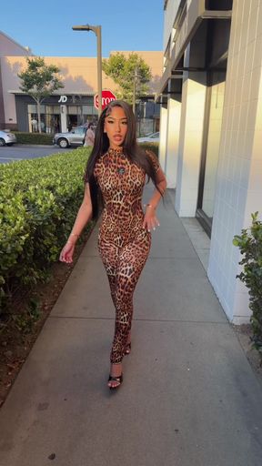 Female in leopard print walking on sidewalk
