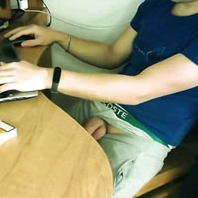 Teen boy jerking off by the desk while working online